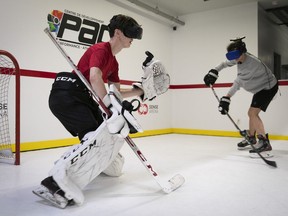 Goalie Loucas Demers and centre Loudric Cloutier use virtual reality gear to help their game at of Centre de développement PAC in Mascouche on Nov. 11, 2020.