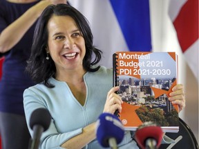Montreal Mayor Valérie Plante holds up a copy of the city's budget for the coming year at a press conference on Thursday, November 12, 2020.