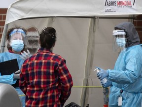 Health care workers check people in at the Parc Ave. COVID-19 testing site in Montreal Nov. 12, 2020.