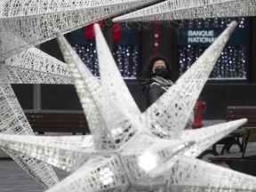 A woman gets a look at the Holidays stars on display at Place d'Armes on Nov. 15, 2020.