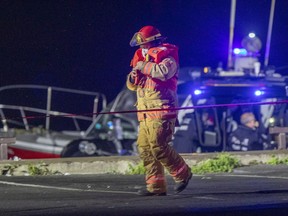 Firefighter is seen at the pier at 34th Ave. and St-Joseph Blvd. in Lachine after a car drove off the pier into the water on Tuesday, Oct. 6, 2020.