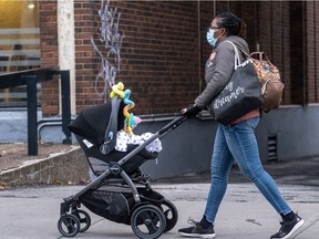 A Montrealer wears a mask as she pushes a stroller on Monday, Nov. 23, 2020
