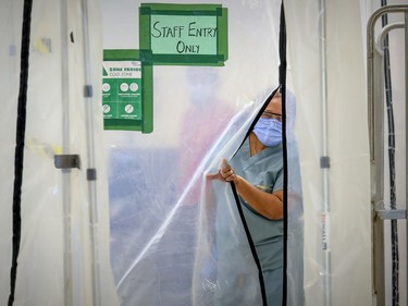 Annie Boto, head nurse in the hot zone, slips through a plastic wall separating the closed-off area at Maimonides Geriatric Centre in Côte-St-Luc on Tuesday, Nov. 24, 2020.