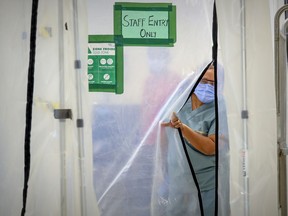 Annie Boto, head nurse in the hot zone, slips through a plastic wall separating the closed-off area at Maimonides Geriatric Centre in Côte-St-Luc on Tuesday, November 24, 2020.
