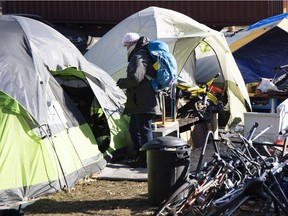 A city worker speaks with homeless people living in unofficial tent city in Montreal in November 2020.