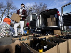 Connor Wareham separates and moves boxes of glass bottles as he volunteers at the Genie in a Bottle — Drive-thru Bottle Drive held outside Pointe-Claire city hall, Saturday. The event was organized by Shirley Cavanagh, a two-time cancer survivor, who wanted to give back to VOBOC, a charity which helped her as a young adult cancer patient, as well as to the Betty Riel Fund that helps fund transportation for cancer patients through SEBEC.