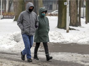 A couple wear masks as they go for a walk in Parc La Fontaine on Nov. 26, 2020.