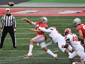 Demarcus Elliott (94) of the Indiana Hoosiers applies pressure to quarterback Justin Fields of the Ohio State Buckeyes forcing Fields to throw an interception in the first quarter at Ohio Stadium on Saturday, Nov. 21, 2020, in Columbus, Ohio. Ohio State defeated Indiana 42-35.