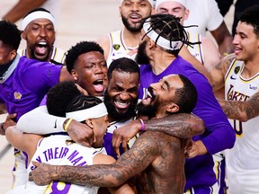 LeBron James #23 of the Los Angeles Lakers celebrates with Quinn Cook #28 of the Los Angeles Lakers and teammates after winning the 2020 NBA Championship in Game Six of the 2020 NBA Finals at AdventHealth Arena at the ESPN Wide World Of Sports Complex on October 11, 2020 in Lake Buena Vista, Florida.