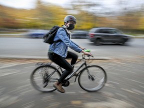 A cyclist wears a mask while using the Rachel St. bike path in Montreal Wednesday October 28, 2020.
