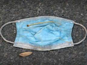 A discarded surgical mask lays on the pavement on Wellington St. in the Verdun borough of Montreal Saturday, October 31, 2020.