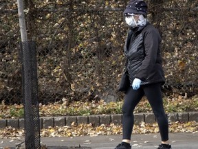 A woman wears gloves, a mask and a face shield in Montreal Nov. 6, 2020.
