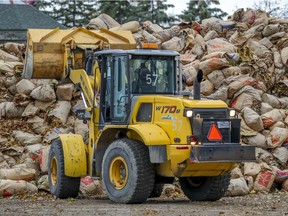 A front-end loader stacks bags of leaves in a municipal parking lot in Dorval, west of Montreal Wednesday November 11, 2020.  Dorval composts their leaves and makes the compost available to residents in the spring.
