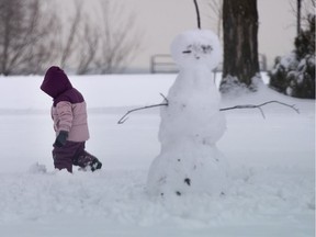 A young girl gets a few minutes of fresh air while making a snowman. It's important to make time to get outside this holiday break.