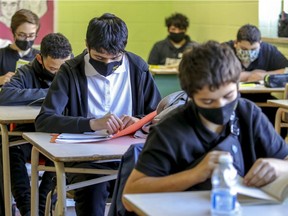 Students read at their desks at John F. Kennedy High School in Montreal on Tuesday. The CAQ government is re-examining the issue of ventilation is schools after new data emerged on aerosol transmission of the coronavirus.