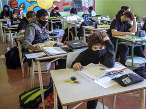 All children should be wearing masks in the classroom — not only Grades 5 and up, writes columnist Saleema Nawaz. Above: Masked students read at their desks at John F. Kennedy High School in Montreal on Nov. 10, 2020.