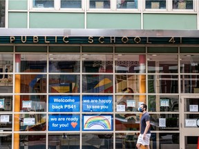 A pedestrian walks past Public School 41 following the outbreak of the coronavirus disease (COVID-19) in the Manhattan borough of New York City, New York, U.S., September 27, 2020. REUTERS/Jeenah Moon/File Photo