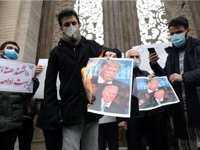 Protesters burn pictures of U.S. President-elect Joe Biden and U.S. President Donald Trump during a demonstration against the killing of Mohsen Fakhrizadeh, Iran's top nuclear scientist, in Tehran on Saturday, Nov. 28, 2020.