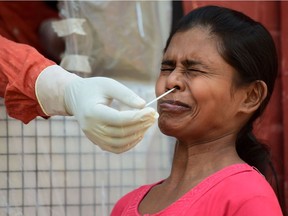 A health worker collects a swab sample from a woman to test for the Covid-19 coronavirus at sample collection centre in Allahabad on October 29, 2020.