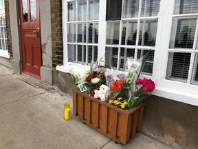Flowers and a candle are placed in front of the house of a woman who died in the Halloween attack on Saturday, Oct. 31, 2020, in Quebec City.