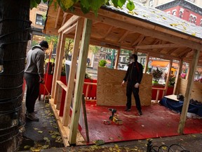 Workers build up an outdoor area outside a restaurant in New York on November 13, 2020. Bars and restaurants in New York will shut early on November 13 under fresh curbs designed to slow soaring Covid-19 infections as the number of daily deaths across the globe topped 10,000 for the first time since the pandemic began.