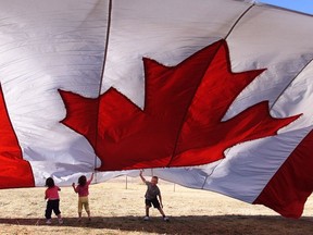 Kids play under a giant flag used as a canopy in this file photo from an Alberta campground. Even Canadians use terms like "the American dream," Martine St-Victor notes. Why not "the Canadian dream"?