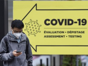 A man walks past a COVID-19 testing clinic in Montreal, Friday, Oct. 16, 2020.