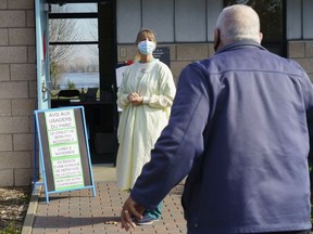 A nurse welcomes a man at a COVID-19 testing clinic in Montreal on Monday, Nov. 9, 2020.
