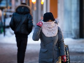 A woman adjusts her scarf as she crosses Parc avenue near the corner of Laurier avenue on Jan. 22, 2013.