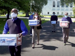 This June 26, 2020 file photo from video provided by the Yes on Measure 110 Campaign shows volunteers delivering boxes containing signed petitions in favor of the measure to the Oregon Secretary of State's office in Salem. The measure said the U.S., possession of small amounts of heroin, cocaine, LSD and other hard drugs would be decriminalized in Oregon. Election returns show the measure passed on Election Day, Tuesday, Nov. 3.