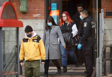 Employees are escorted out of Ubisoft in Montreal during a police operation on Nov. 13, 2020.