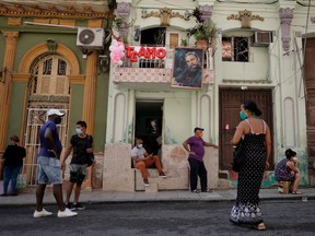 People line up to buy food under a picture of late Cuban President Fidel Castro set up for the celebrations of the 60th anniversary of the Committees for the Defence of the Revolution (CDR), amid concerns about the spread of the coronavirus disease (COVID-19), in Havana, Cuba, on Sept. 28, 2020.