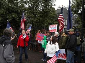 Geena Shipman uses a megaphone as a group of supporters of U.S. President Donald Trump protest against restrictions put in place to limit the spread of coronavirus disease (COVID-19) outside the governor's mansion, Mahonia Hall, in Salem, Oregon, U.S., November 21, 2020. REUTERS/Alisha Jucevic