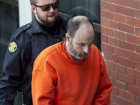Matthew Raymond is escorted at Court of Queen's Bench in Fredericton on December 18, 2019.