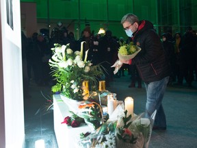 Quebec City Mayor Régis Labeaume lays flowers at a vigil to honour François Duchesne, who was killed on Halloween night by a man with a sword, Tuesday, November 3, 2020 in Quebec City.