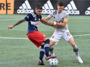 Montreal Impact defender Jukka Raitala, right, and New England Revolution forward Gustavo Bou battle during the first half at Gillette Stadium in Foxborough, Mass., on Sept. 23, 2020