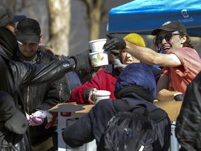 Resilience Montreal cook Sam Schuette hands out food to homeless people in Cabot Square in Montreal on March 27, 2020.