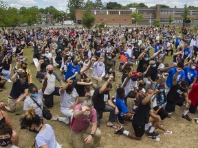 People raise their arms at an event called Montreal Kneels for Change at Loyola park in Montreal Sunday, June 7, 2020. "More and more other people are coming forward to stand in solidarity with the Black community," Fariha Naqvi-Mohamed writes.
