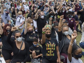 People raise their arms at an event called Montreal Kneels for Change at Loyola park in Montreal Sunday, June 7, 2020. Martine St-Victor says that one thing that made her proud in 2020 was the diversity of the crowds at Black Lives Matter protests.