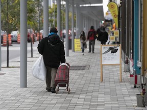 People walk down the newly renovated sidewalk at Plaza St-Hubert on Oct. 22, 2020.