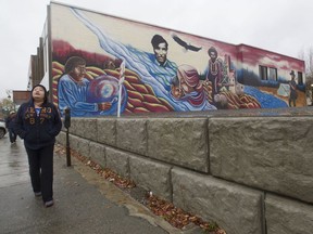 Ashley Esau walks by a mural in Val-d'Or in 2015, after allegations surfaced that Sûreté du Québec officers had sexually and physically abused Algonquin women while on duty.