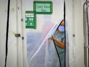 Annie Boto, head nurse in the hot zone, slips through a plastic wall separating the closed-off area at Maimonides in Côte-St-Luc.