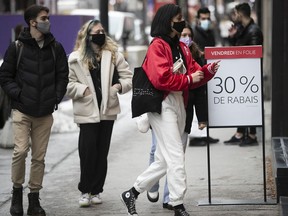 Montreal shoppers make their way into a store for Black Friday sales on Ste-Catherine St. on Friday, Nov. 27, 2020.