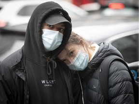 A Montreal couple stands in line in front of a downtown store for Black Friday on Nov. 27, 2020.