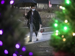 A man walks past a Christmas scene at Place de la Gare-Jean-Talon in Park Extension on Dec. 1, 2020.