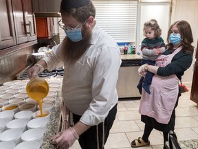 Rabbi Levi Naparstek pours sweet potato soup while his wife, Chaya Raskin Naparstek, and their 18-month-old son Yosef look on. The rabbi started Smile on Seniors, and one of the program’s most popular offerings is a Wednesday night home-cooked meal.