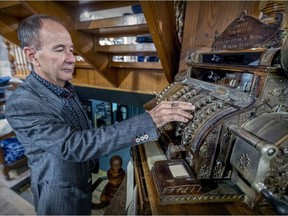 Philippe D'Aoust, owner of G. Daoust & Cie., with the 1912 cash register in the 120-year-old department store his grandfather founded in Ste-Anne-de-Bellevue.