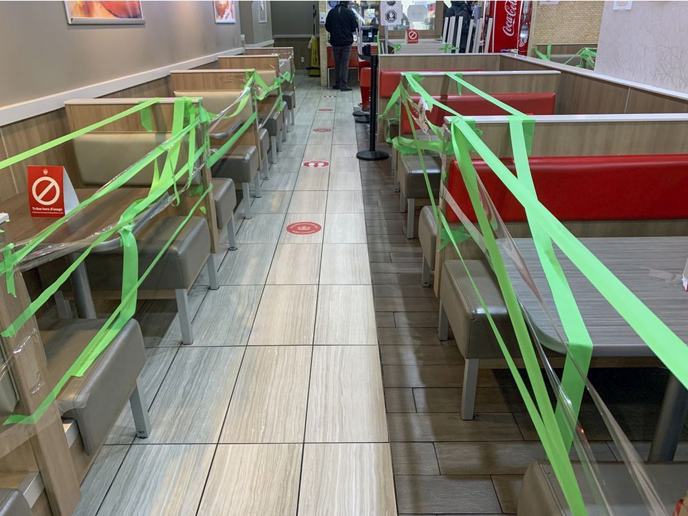 Tables and booths are wrapped in tape to keep customers from dining in at a Burger King restaurant in Montreal in October 2020.