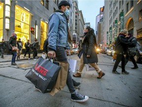 A shopper crosses Metcalfe St. at Ste-Catherine St. in Montreal Friday December 11, 2020.