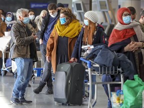 Travellers line up for at Pierre Elliott Trudeau International Airport in Montreal Friday.